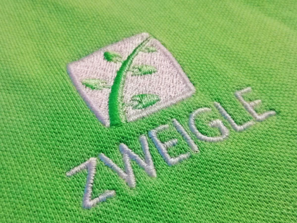 Besticktes, grünes Poloshirt für Praxis Zweigle in Detailansicht. Textilveredlung von DOWE