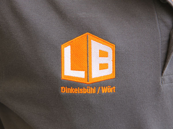 Besticktes graues Poloshirt mit Logo von Launer Bau, umgesetzt von DOWE, Detailansicht - Man sieht die feine Sticktextur