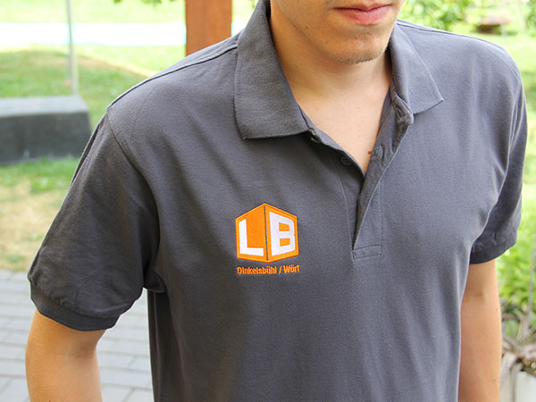 Besticktes graues Poloshirt mit Logo von Launer Bau, umgesetzt von DOWE